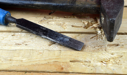 
a hammer and a chisel lies on the table in the workshop