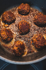 plant-based food, vegan meatballs made of black beans mushroom mince and textured vegetable protein getting pan fried