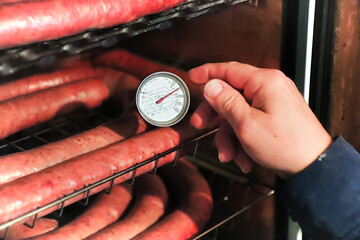 Checking the temperature of sausages to see if they are cooked