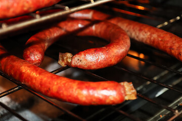 Fototapeta premium Racks of ham sausages drying in an oven after being bloomed