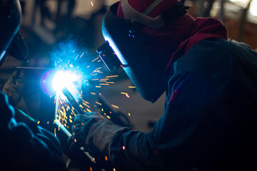 Metal workers use manual labor, Skilled welder, Factory workers making OT. Welder is welding the steel in the factory.