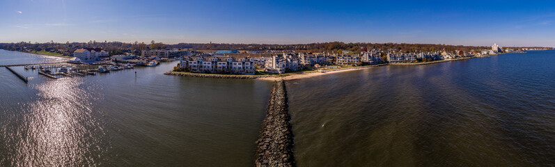Obraz premium Aerial view of Chesapeake Beach marina with luxury sail boats, beach house apartments, fishing boats near the water park popular vacation spot for Washington residents in Calvery county Maryland