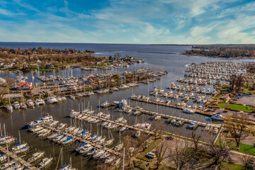 Fototapeta na wymiar Scenic aerial panorama of Deale waterfront docks on the Western Shore of Chesapeake Bay Maryland, dozens of luxury sailboats docking in the marina. 