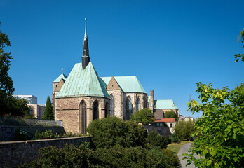 Fototapeta na wymiar Magdalenenkapelle am Ufer der Elbe bei Magdeburg. Dahinter die Petrikirche und die Wallonerkirche
