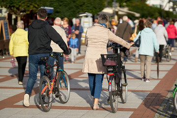 Obraz premium Tourists with bicycles on the popular beach promenade of Swinoujscie in Poland