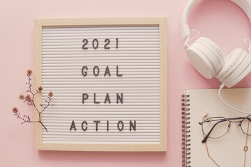 2021 New year resolution, Goal, Plan and action on letter board with notepad and headphone