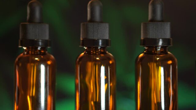 CBD oil in laboratory with marijuana background, hemp oil, essential oils, and alternative medicine 