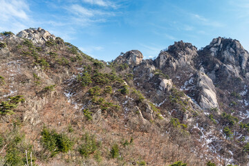 Fototapeta na wymiar Bukhansan Mountain national park with rocks, snow, and dead trees in the spring in Seoul of South Korea.