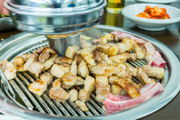Korean food, grilled pork barbecue on hot metal plate looks tasty and delicious