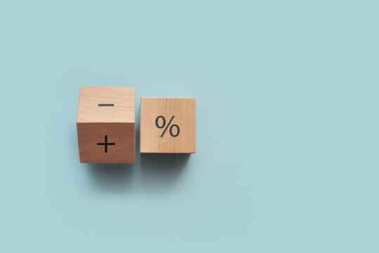 Wooden cubes with the image of percentages, plus and minus. Increase or decrease in interest on profit or credit
