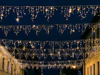 old town street decorated with christmas lights. winter holidays decorations.