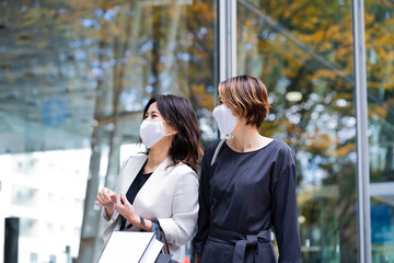 マスクをつけてウィンドウショッピングを楽しむ女性2人