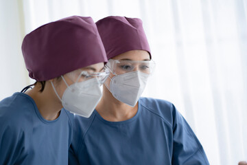 医療用ゴーグルをかけて手術着を着た医療従事者