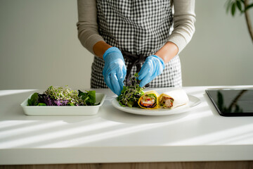 手袋をつけて料理をする女性の手元