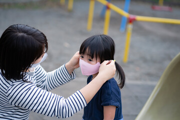 子供にマスクをつける母親