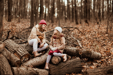 Emotional kids siblings in an autumn winter park with foliage, sisters children walk together in an autumn forest, brown toning