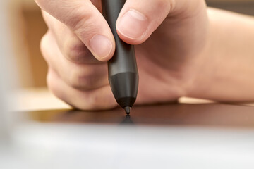 Girl draws on a graphics tablet with pen. Close-up, selective focus