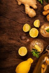 Ginger Ale Cocktail with Beer, Lime, Lemon and Mint in glaass on wooden table, top view