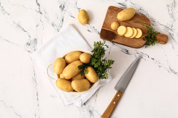 Composition with raw potatoes on light background