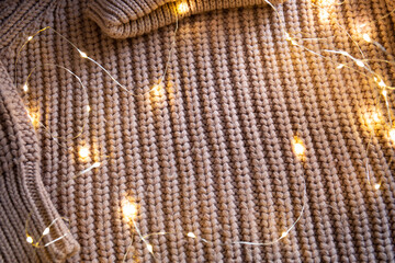 Knitted fabric background with glowing garland