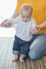 Naklejka premium Happy father playing with adorable baby in the room at home.