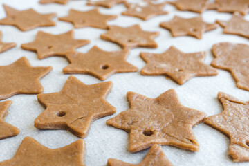 Fototapeta na wymiar gingerbread cookie dough cut into stars prepared to be baked on parchment paper