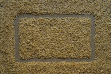 The rectangular frame is drawn on small noodles scattered on gray linen canvas