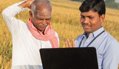 Confused Indian farmer Scratching his head while banker or corporate government officer discussing...