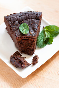 A slice of cocoa and aubergine pur�e cake with mint leaves