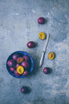 Fresh damsons, partially halved and pitted (seen from above)