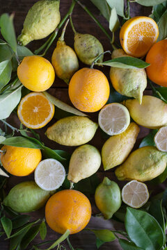 Various organic citrus fruit with leaves on a rustic table