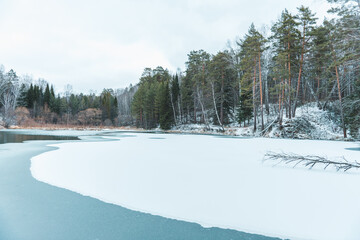 Small beautiful pond in the snow forest. Selective focus. Winter landscape.