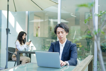 テラス席でパソコンを使う男性