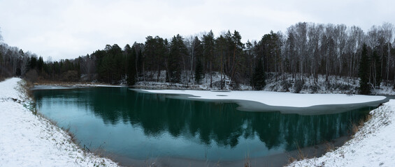 Small beautiful pond in the snow forest. Selective focus. Winter landscape.
