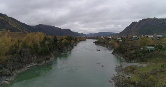 Aerial view by drone of Katun scenic mountain river flowing along Chemal village, Altai Republic, Russia