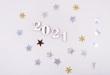 Close-up of wooden numbers 2021 on grey background with stars. Holidays content