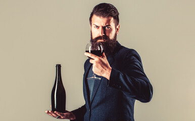 Red wine in bottle, wine glass. Red wine in a glass. Sommelier man, degustator, winery. Bottle, red...