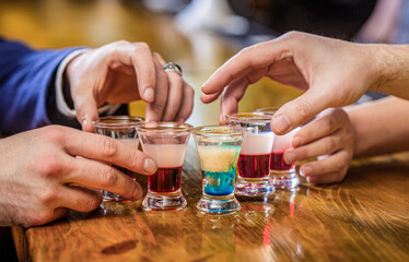 Friends drink shot or liqueur. Five glasses of alcohol.Tequila shots, vodka, whisky, rum. Cocktail...