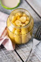 Pickled young baby corn cobs in jar.