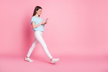 Full size profile side photo of positive girl use smartphone go copyspace isolated over pastel color background