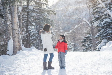 Fototapeta na wymiar Asian mother and son enjoying beautiful cold winter sunny day