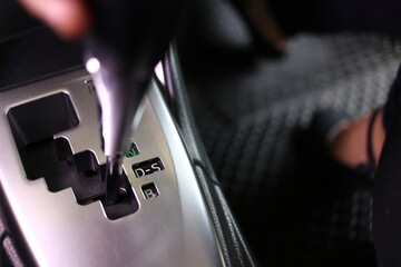 Selective focus, Lady hand on automatic gear shift. The driver's hand moved the gear selector to (D) mode of the automatic transmission in the car