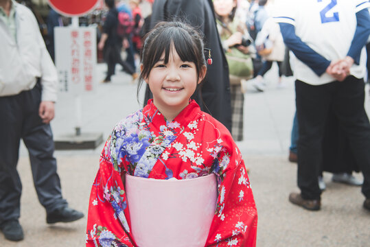 Beautiful Asian girl wearing red kimono walking in the city