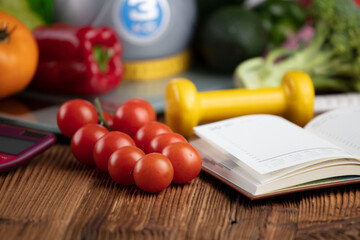 Fitness concept. Healthy nutrition: fruits and vegetables. Equipment for fitness exercises: weighing machine and dumbbells. 