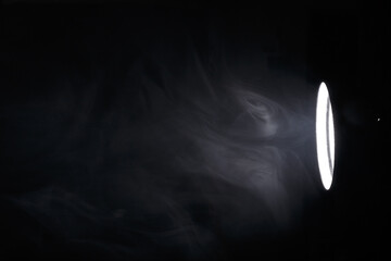 flashlight or spotlight through the smoke. Light beam on a dark background. Haze