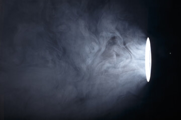 flashlight or spotlight through the smoke. Light beam on a dark background. Haze