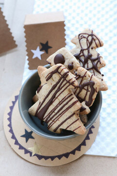 Gluten-free shortbread biscuits shaped like Christmas trees with chocolate icing