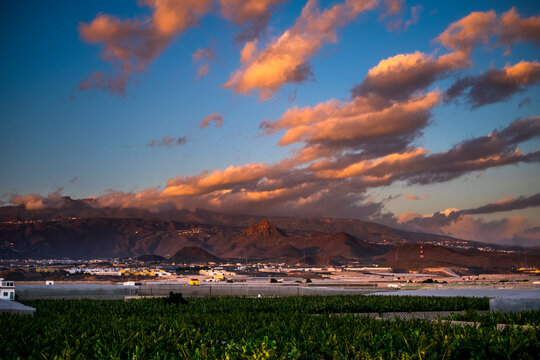 Landscape sunset beautiful view of tree bananas plantation and mountains in background with colorful amazig clouds in the blue sky