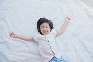 Cute asian child lying on white bed