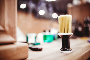 Brush for shaving beard, blurred background of hair salon for men, barbershop